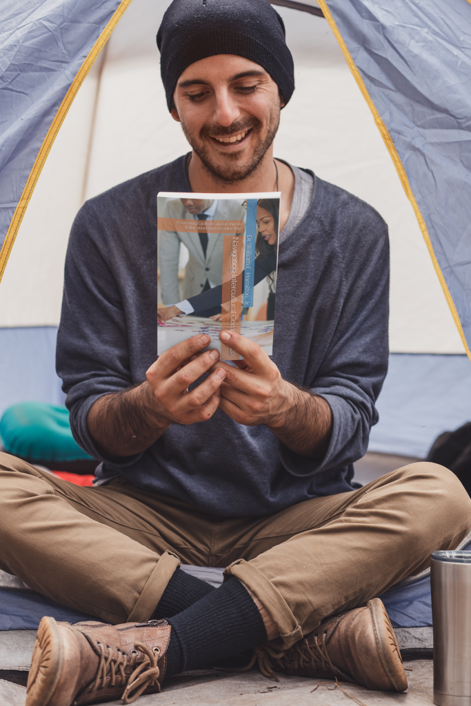 Book mockup featuring a joyful man sitting in a camping tent 30479